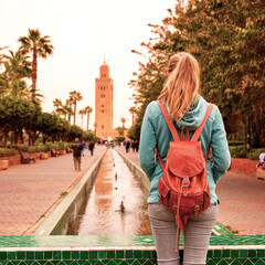 Woman tourist looking at Koutoubia mosque minaret-Tourism in Marrakech, Morocco
