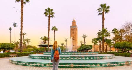 Woman looking at Koutoubia mosque minaret-Tourism in Marrakech, Morocco