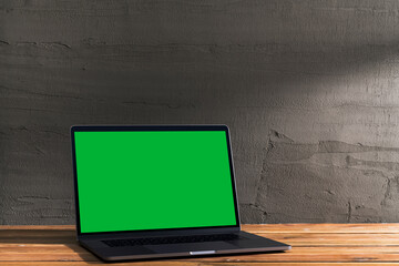 Chroma key green screen, angled view laptop on table