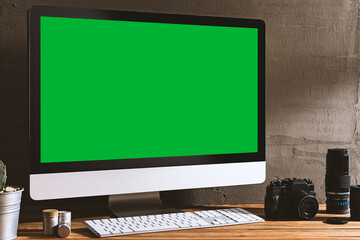 Chroma key green screen, angled view computer on table with photography equipment