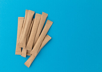 sugar packets on blue background, top view