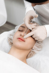 close-up, female lips. Surgeon, in medical gloves, carefully and slowly injects hyaluronic acid into woman's lips with a syringe. lip augmentation procedure. beauty injections. Plastic surgery.