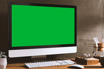 Chroma key green screen, angled view computer on table with a book, glasses and coffee