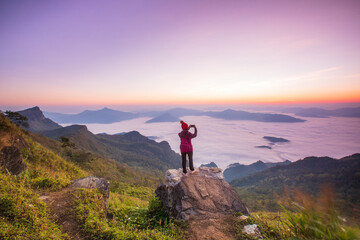 Obraz premium Young woman in red jacket hiking on the high mountain, Phu Chee Duean, border of Thailand and Laos.