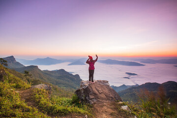 Young woman  in red jacket hiking on the high mountain, Phu Chee Duean, border  of  Thailand and Laos.