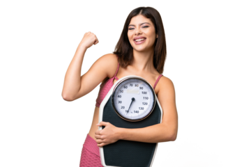 Young Russian woman with rainproof coat and umbrella over isolated chroma key background with weighing machine and doing victory gesture