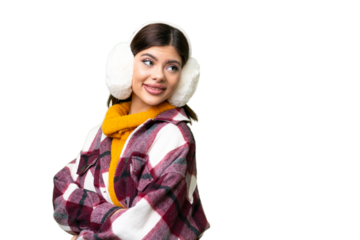 Young Russian woman wearing winter muffs over isolated chroma key background with arms crossed and happy