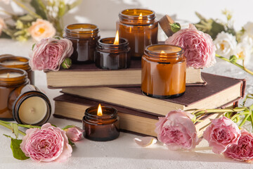 Obraz na płótnie Canvas A set of different aroma candles in brown glass jars. Scented handmade candle. Soy candles are burning in a jar. Aromatherapy and relax in spa and home. Fire in brown jar.