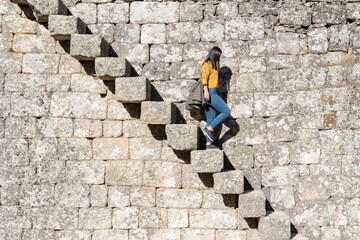 Young girl going down the old stairs of the castle of Monsanto medieval village, Portugal 