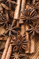 Background with cinnamon sticks, anise stars, coffee beans and nuts. Spicy trendy background. Close-up of various spices on wooden table top view