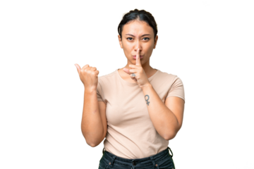 Young Uruguayan woman over isolated chroma key background pointing to the side and doing silence gesture