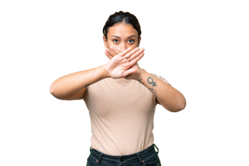 Young Uruguayan woman over isolated chroma key background making stop gesture with her hand to stop an act