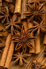 Background with cinnamon sticks, anise stars, coffee beans and nuts. Spicy trendy background. Close-up of various spices on wooden table top view