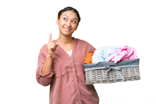Young Uruguayan woman holding a clothes basket over isolated chroma key background pointing up a great idea - Powered by Adobe