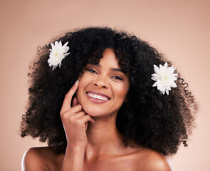 Portrait, hair care and black woman with flowers, smile and texture with girl on brown studio background. Face, African American female and lady with plants, florals and confident with afro or volume