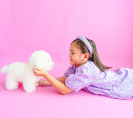 Pretty little girl laying on floor with stuffed animal dog - Powered by Adobe