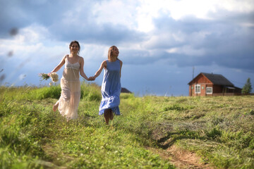 Young girls are walking in the field