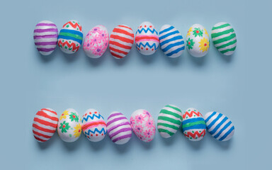 Hand-decorated Easter eggs on blue background with space for message