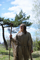 A man in a cassock spends a ritual in a dark forest