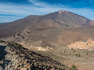 View on Los Roques de Garcia rock formation and colorful volcano Pico del Teide from from top of Alto de Guajara mountain, blue sky, white clouds. Tenerife Canary island