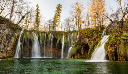 Plitvice Lakes National Park during colorful autumn, Croatia, Europe. Fall colors leafs on trees. Waterfalls and water in sunny morning light with fog. Landscape photography. View of Plitvicka Jezera.