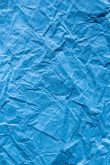 Crumpled blue paper texture background. Wrinkled paper surface for designs.