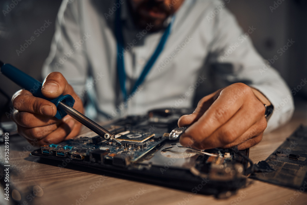 Poster man hands, it or soldering motherboard in engineering workshop for night database fixing. zoom, tech