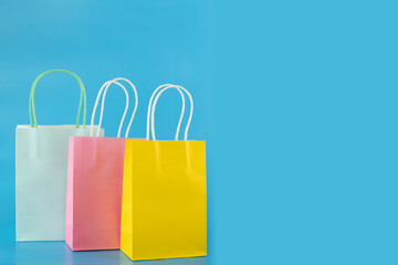 shopping bags on blue background, gift bags, sale and discount, birthday presents, copy space