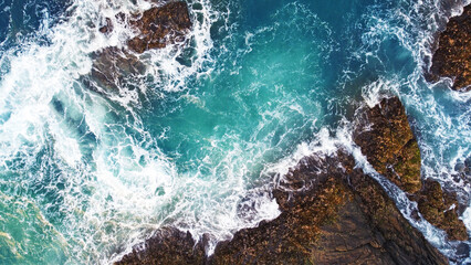 Fototapeta premium Aerial view of the sea rocks cliffs in the ocean. Beautiful sea wallpaper for tourism and advertising. Stormy landscape, drone photo