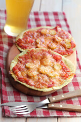 Sausage and tomatoes tortilla pizzas on a wooden board served with light beer - 575292135