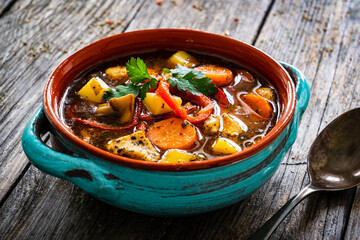 Delicious soup - cooked chicken breast boiled fresh vegetables, lentils, peas and chickpeas on wooden table
