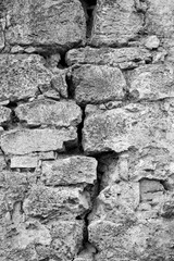 Big crack on old gray wall, abstract image of vertical cleft.  Black and white photo. Close up. Copy space. Selective focus.
