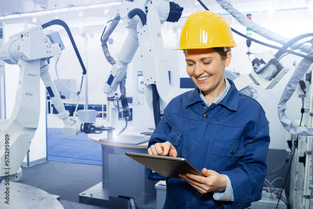 Aufkleber Woman engineer uses a digital tablet to control robots in a smart factory. Smart industry 4.0 concept	