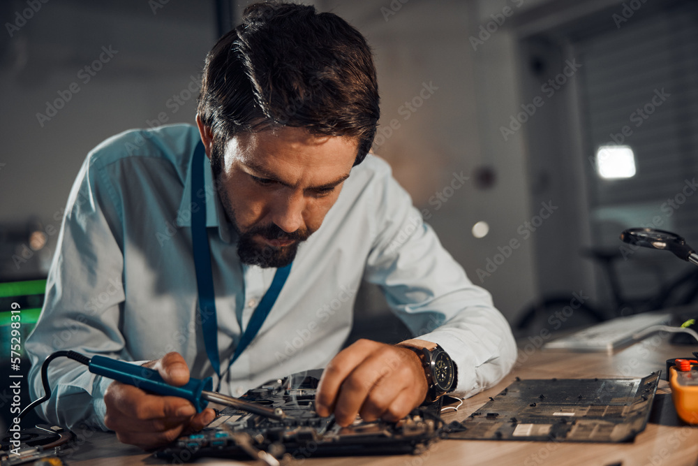 Poster concentration man, it or soldering motherboard in engineering workshop for night database fixing. te