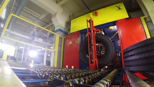 Robot Arm Takes Tire Places into Case Puts on Roll