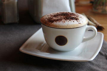 A cup of cappuccino with cinnamon on the cafe table