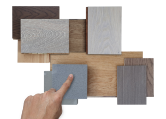 interior architect's hand choosing sample of wood chipboard. wooden laminate veneer material placed with stone tile and engineering flooring tile isolated on background with clipping path.