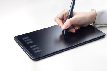 Female hand writing on a wireless graphics tablet on a white background