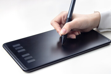 Female hand writing on a wireless graphics tablet on a white background