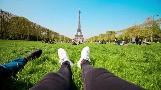 Couple Chilling On The Grass In The Park With Eiffel Tower View In Paris, France