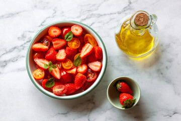 Portion of strawberry and tomato cherry salad decorated with basil leaves