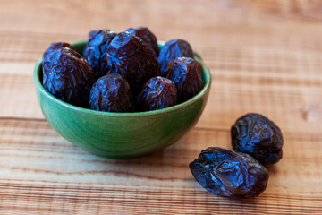Bowl of date fruits on a wooden table