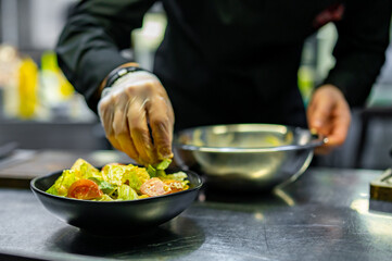 Chef cooking Caesar salad on restaurant kitchen