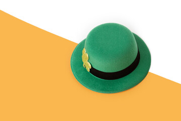 saint patrick day, green irish leprechaun hat with gold clover on orange and white background, copy...