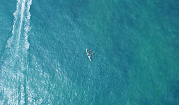 Aerial view of a fishing boat with fishermen in the blue ocean. Beautiful sea wallpaper for tourism and advertising. Asian landscape, drone photo