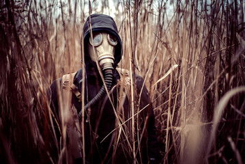 Person with gasmask in bushes