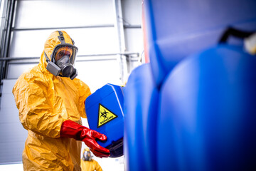 Factory worker with gas mask and protection suit working with toxic and dangerous chemicals.