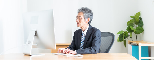 パソコン作業をするシニア日本人男性