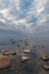 Baltic sea on a gloomy autumn day, view from a shore with stones.