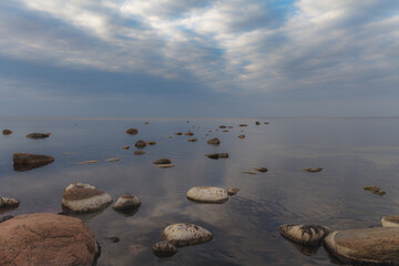 Baltic sea on a gloomy autumn day, view from a shore with stones.